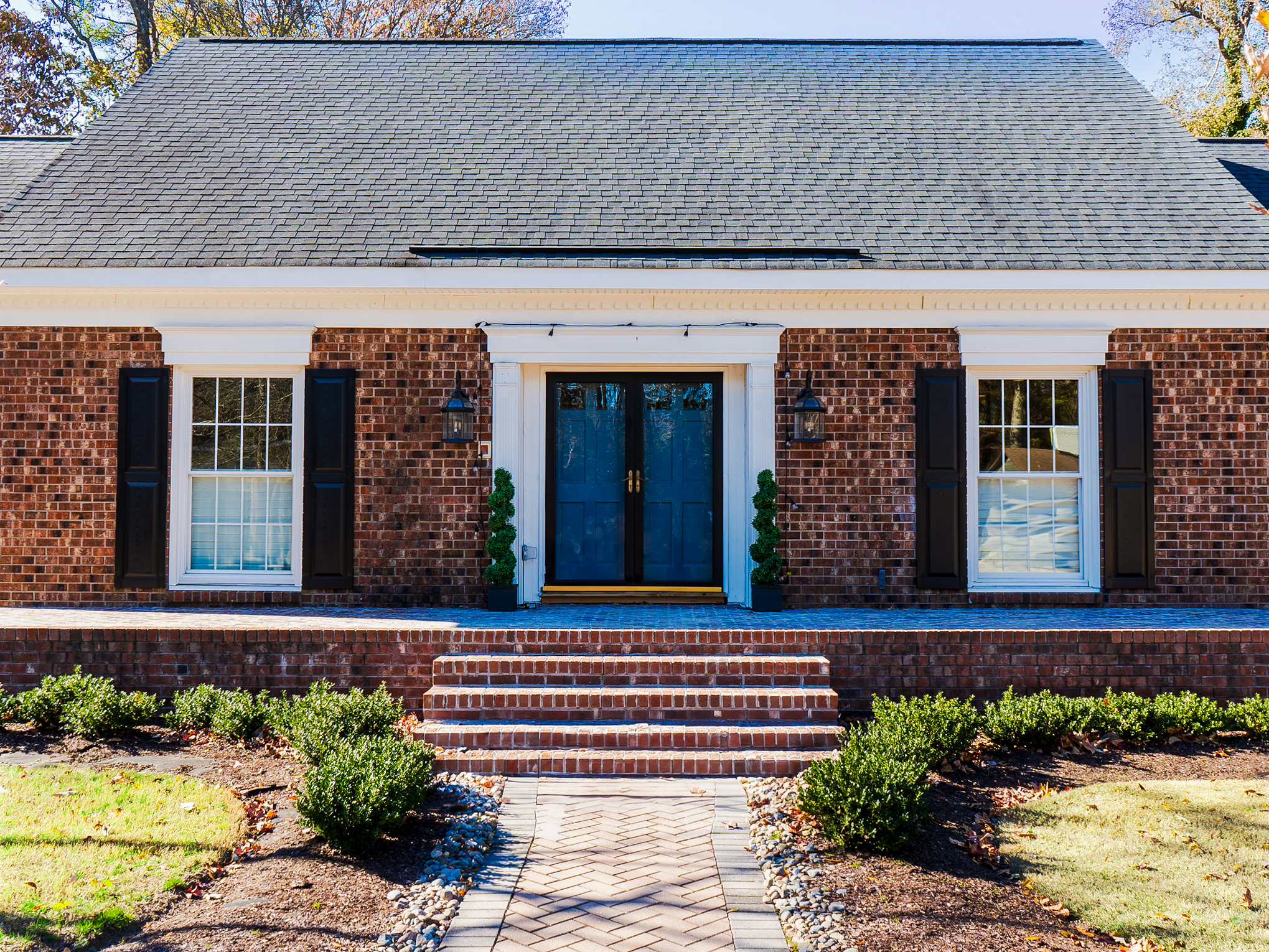 Brick cottage front with double doors.