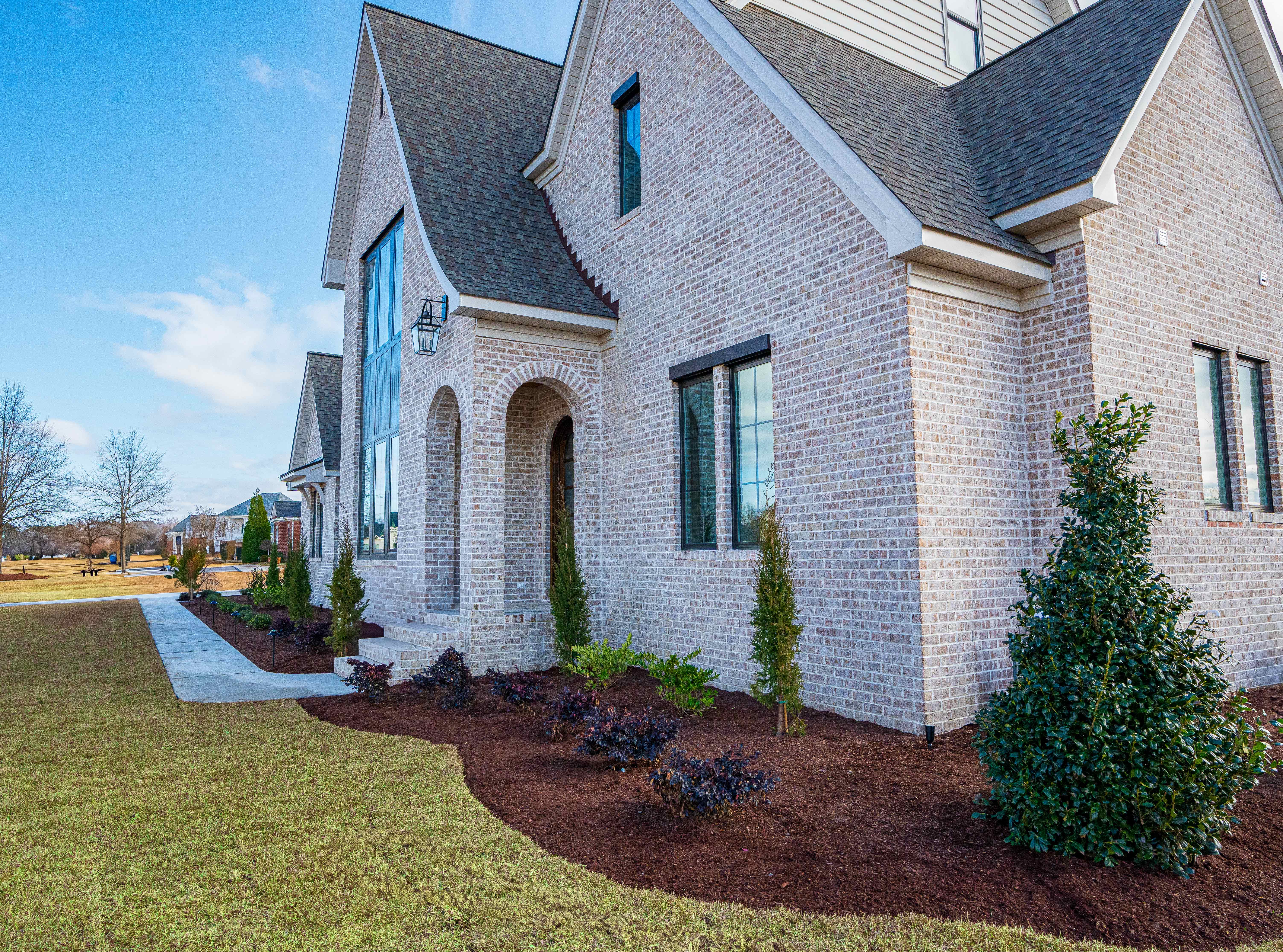 Brick home with arched entry — front elevation.