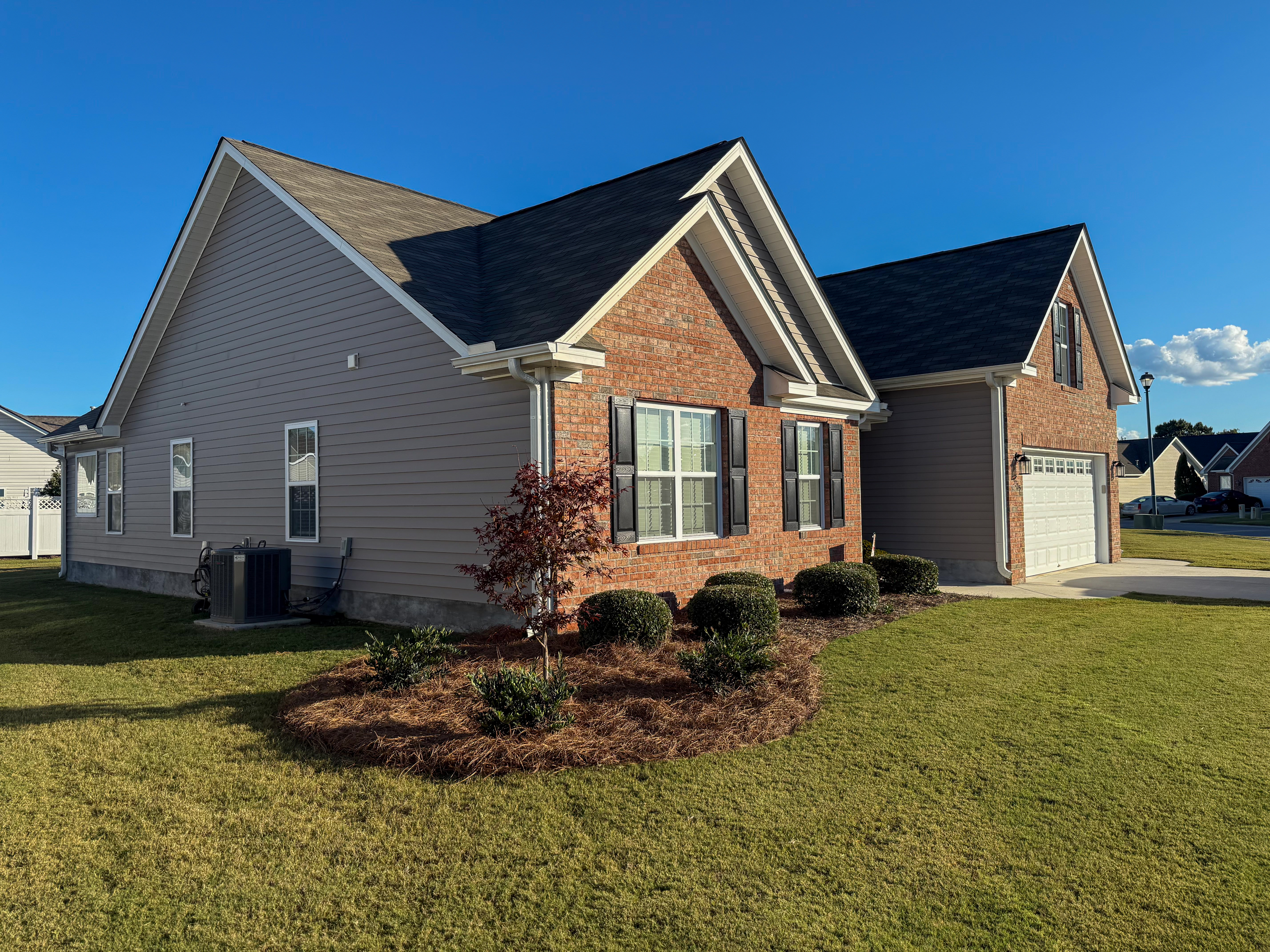 Brick home side elevation with young tree.