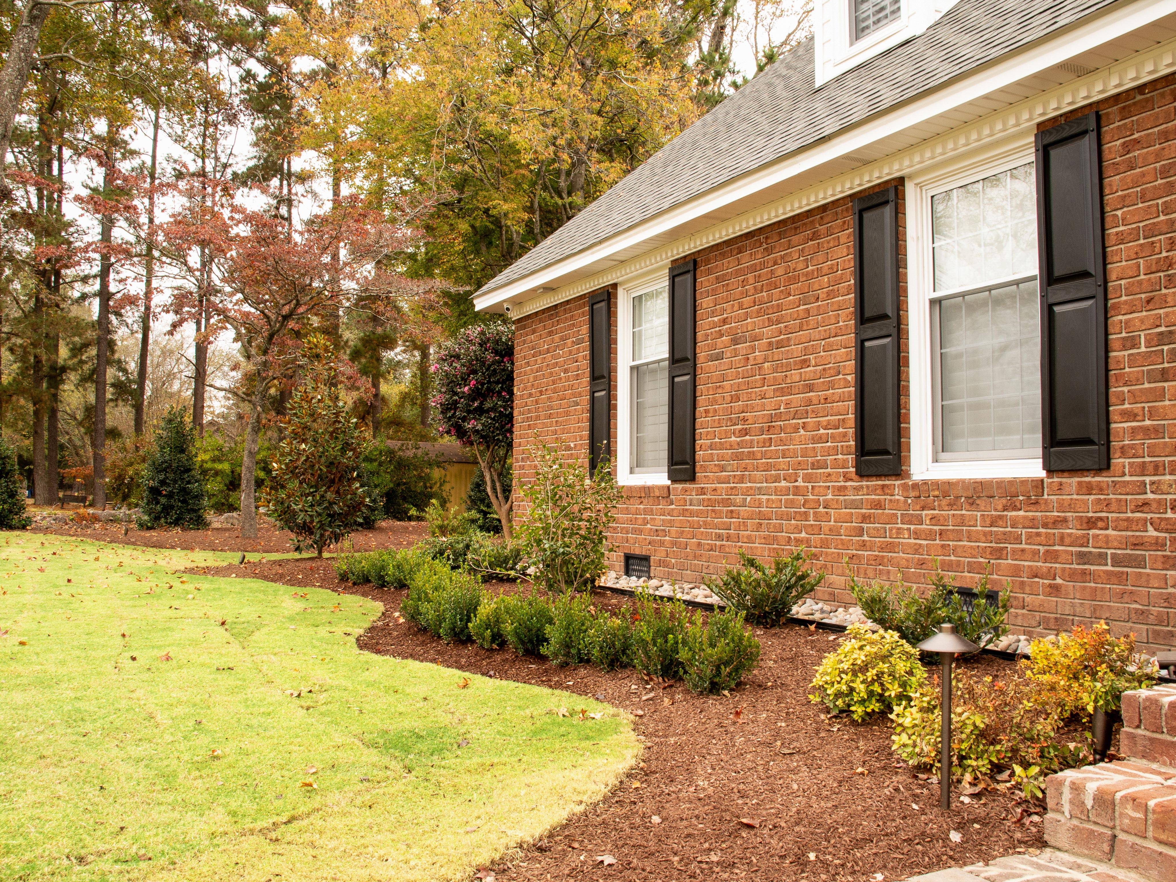 Brick side elevation with shrub bed.
