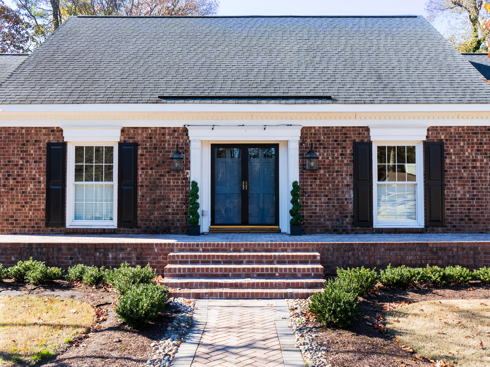 Front entry composition with planting and brick column.