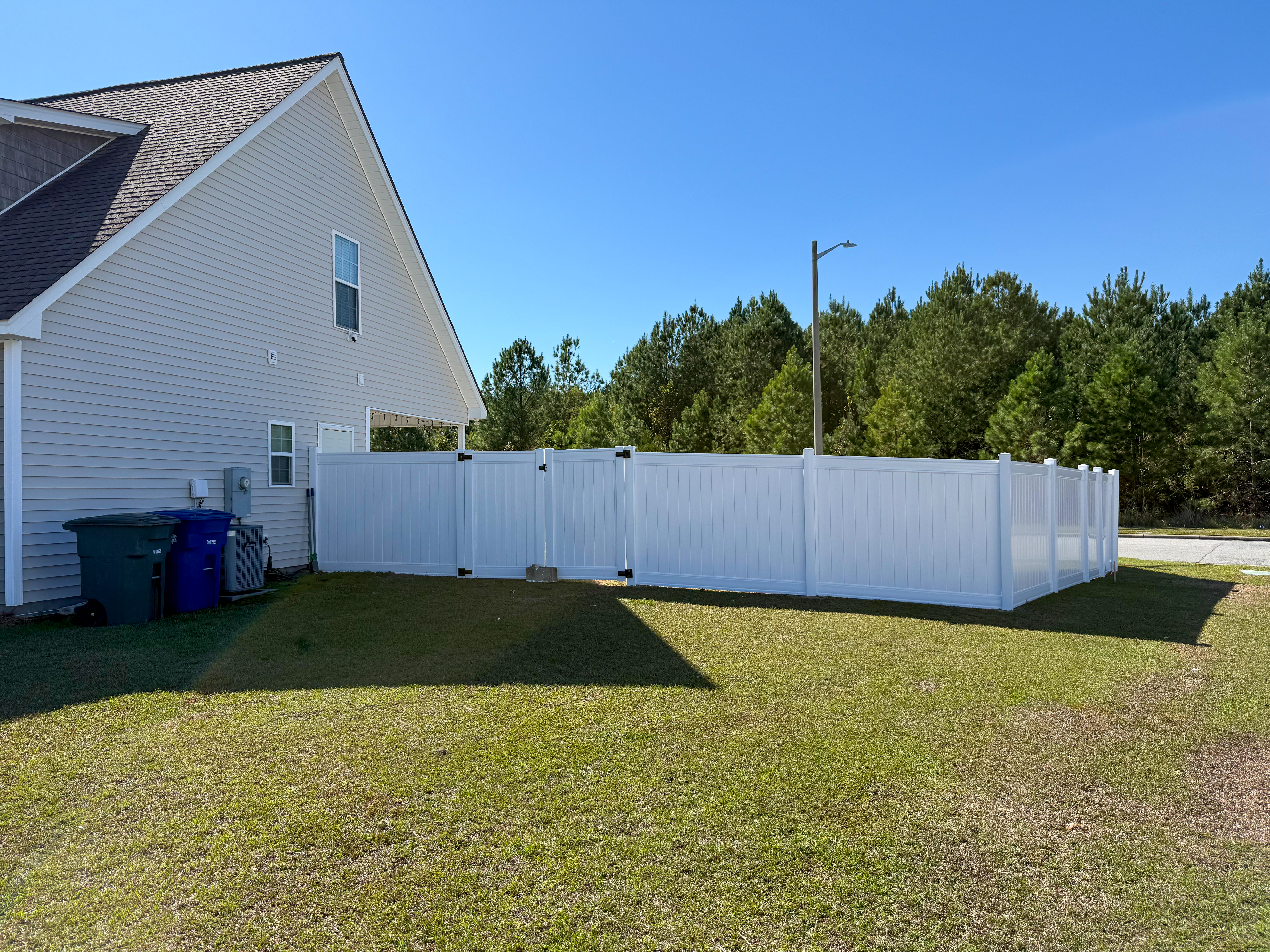 White vinyl fence in a side yard.