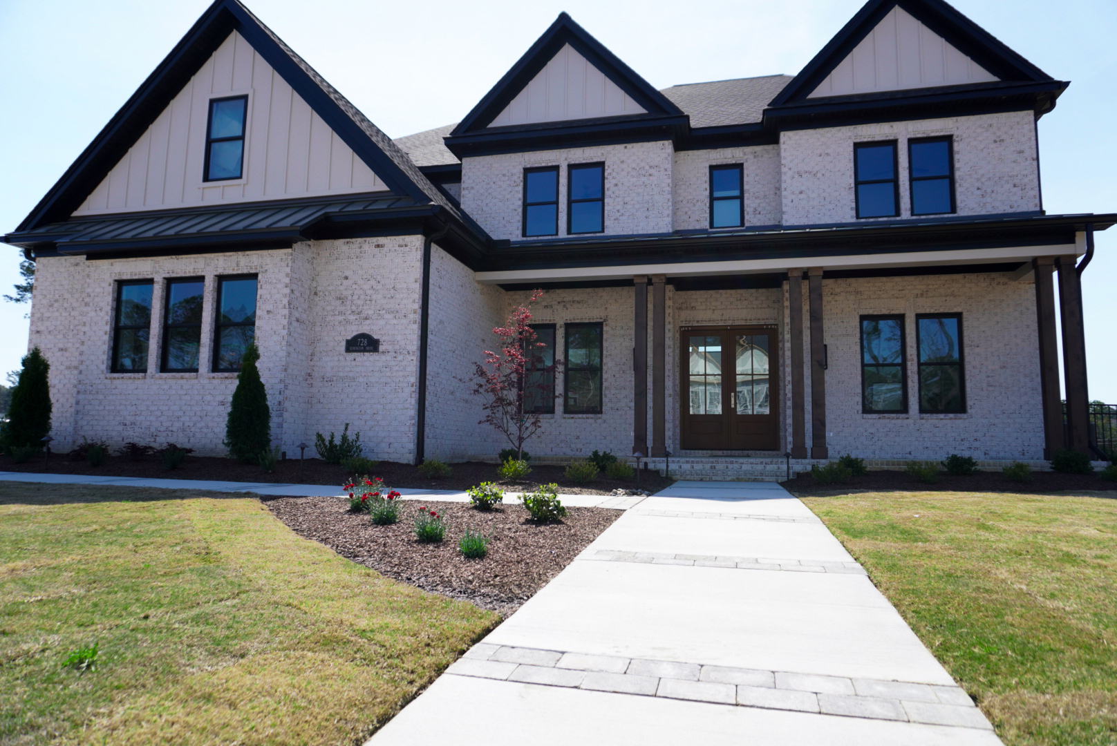 Brick front elevation with paver walk and tulips.