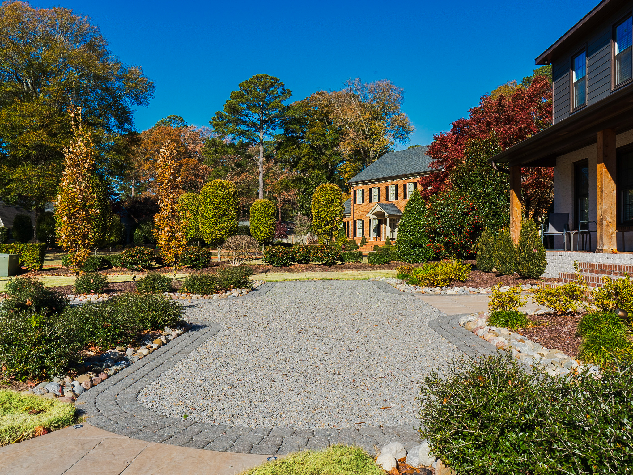Gravel driveway through a formal garden.