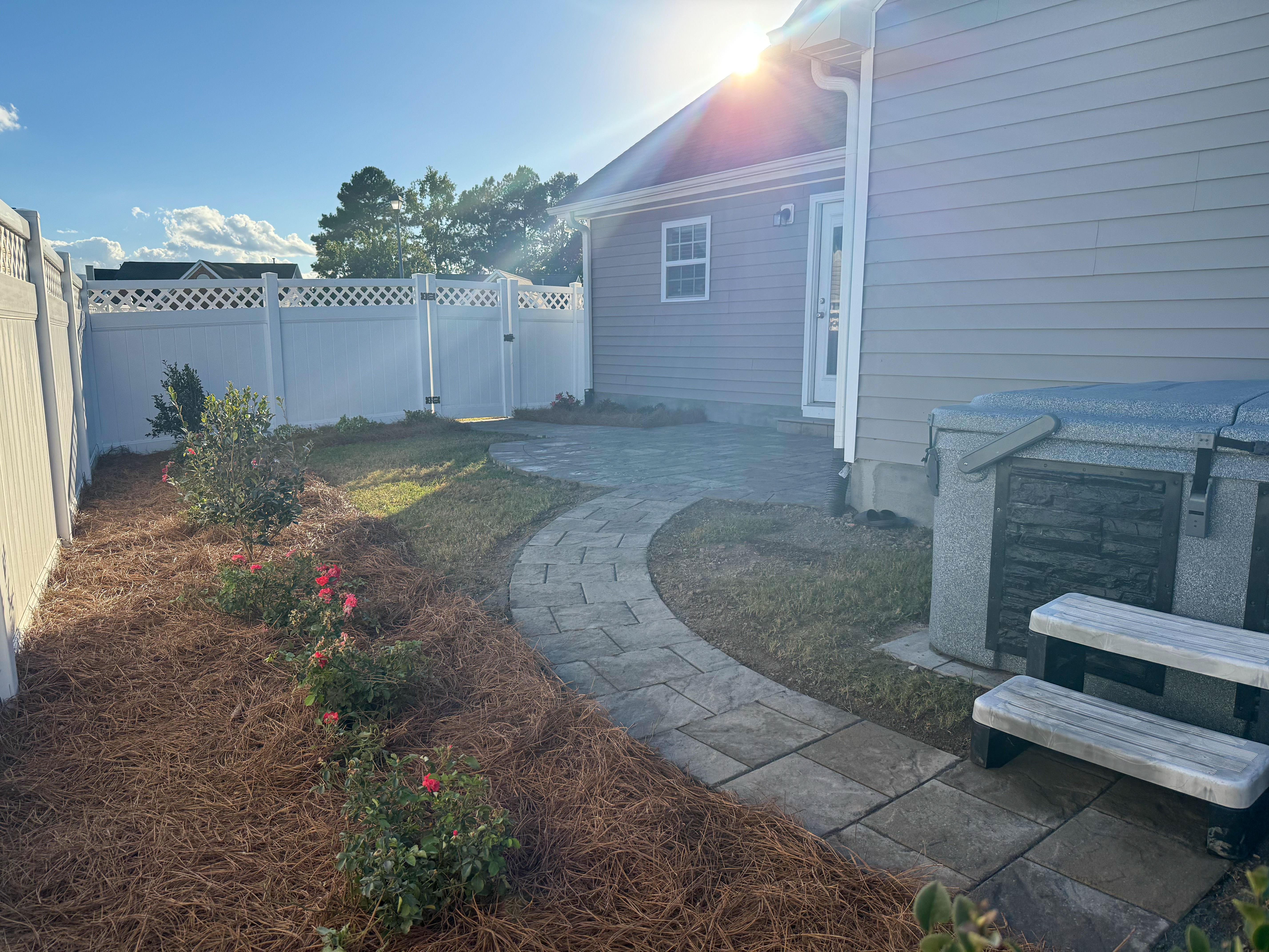 Side-yard paver walkway with fence.