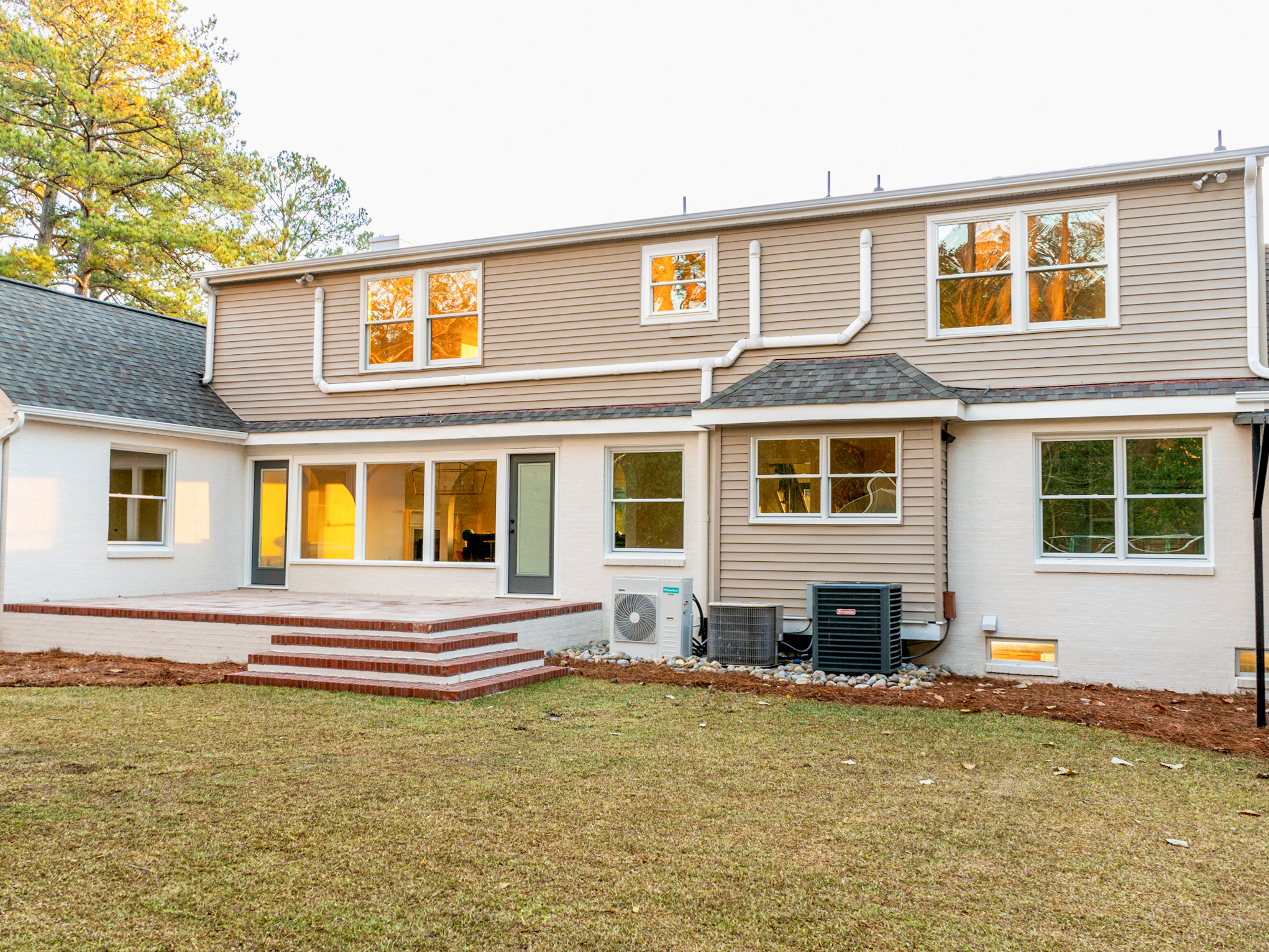 Tan-brick rear elevation with a brick paver patio.
