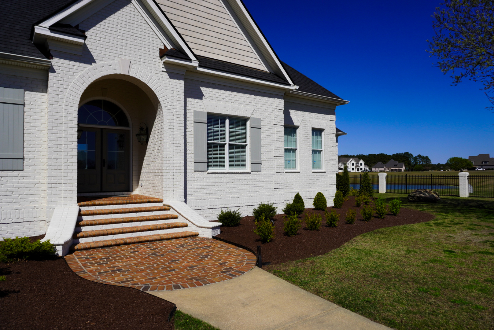 White-brick side entry with paver walkway.