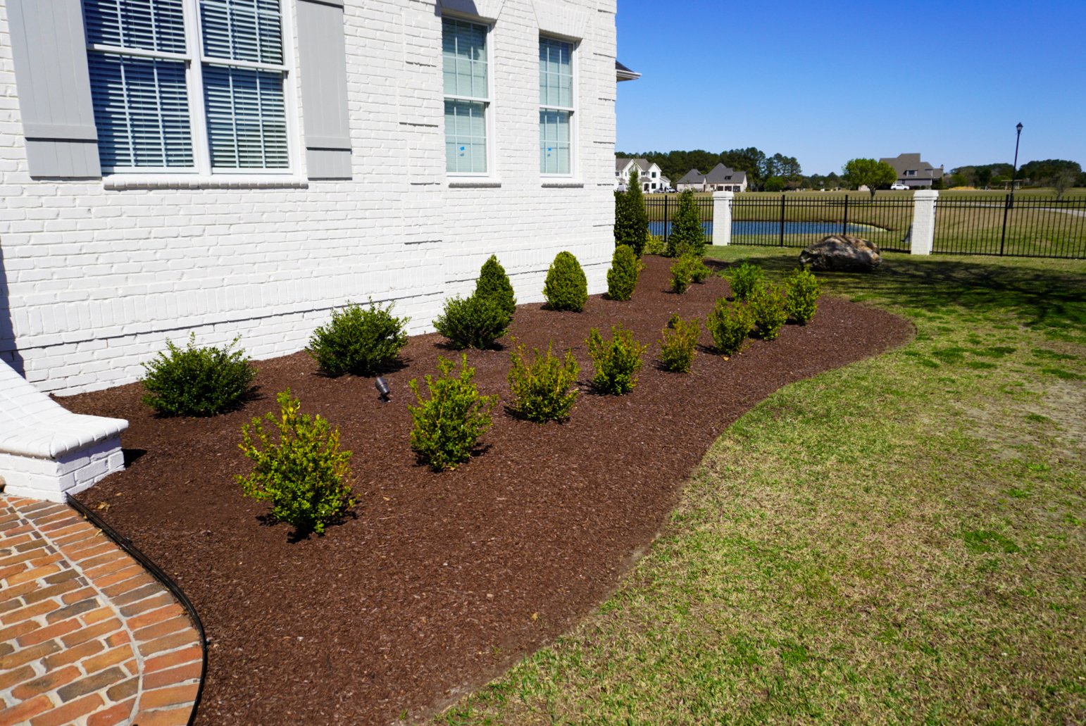 Boxwood foundation bed with pond view.