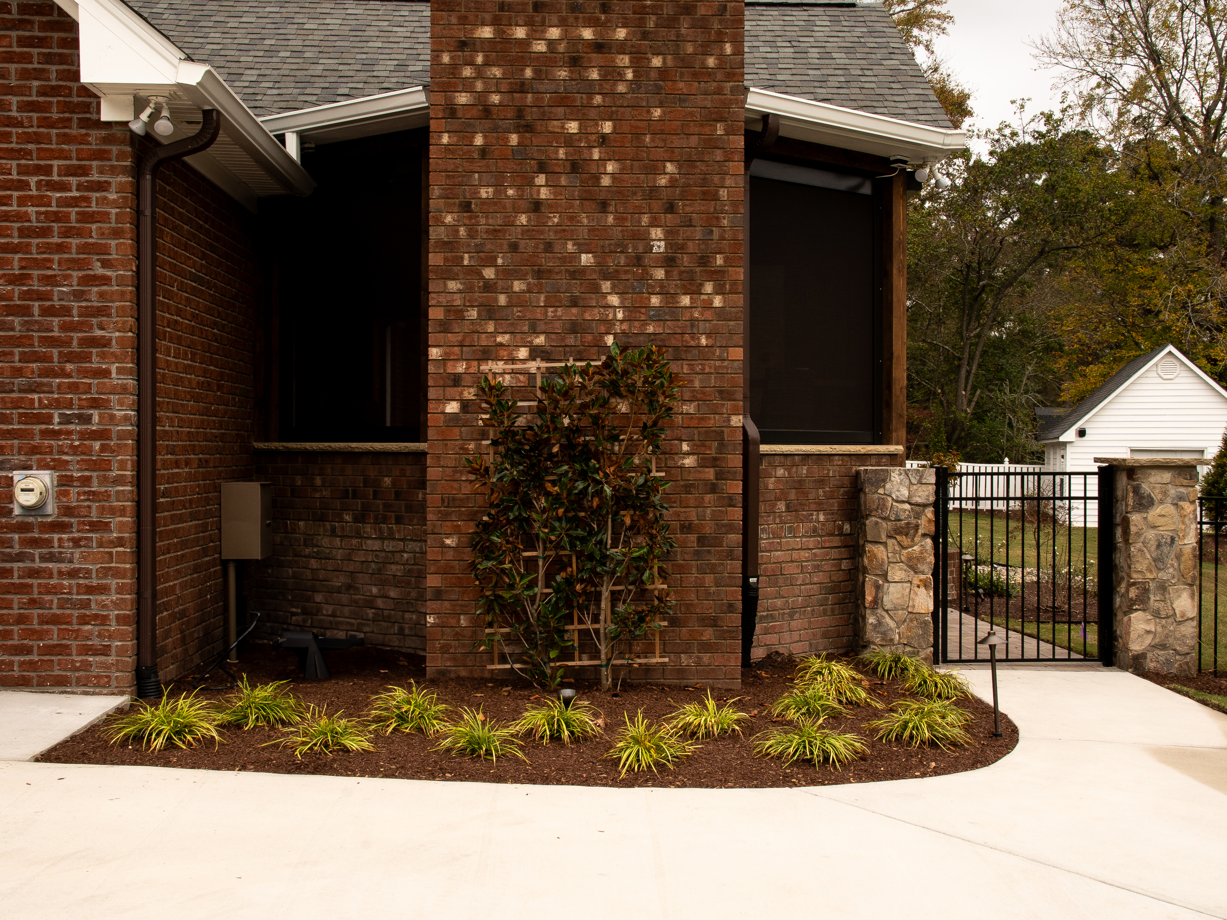 Composed rear yard with multi-level stone terrace.
