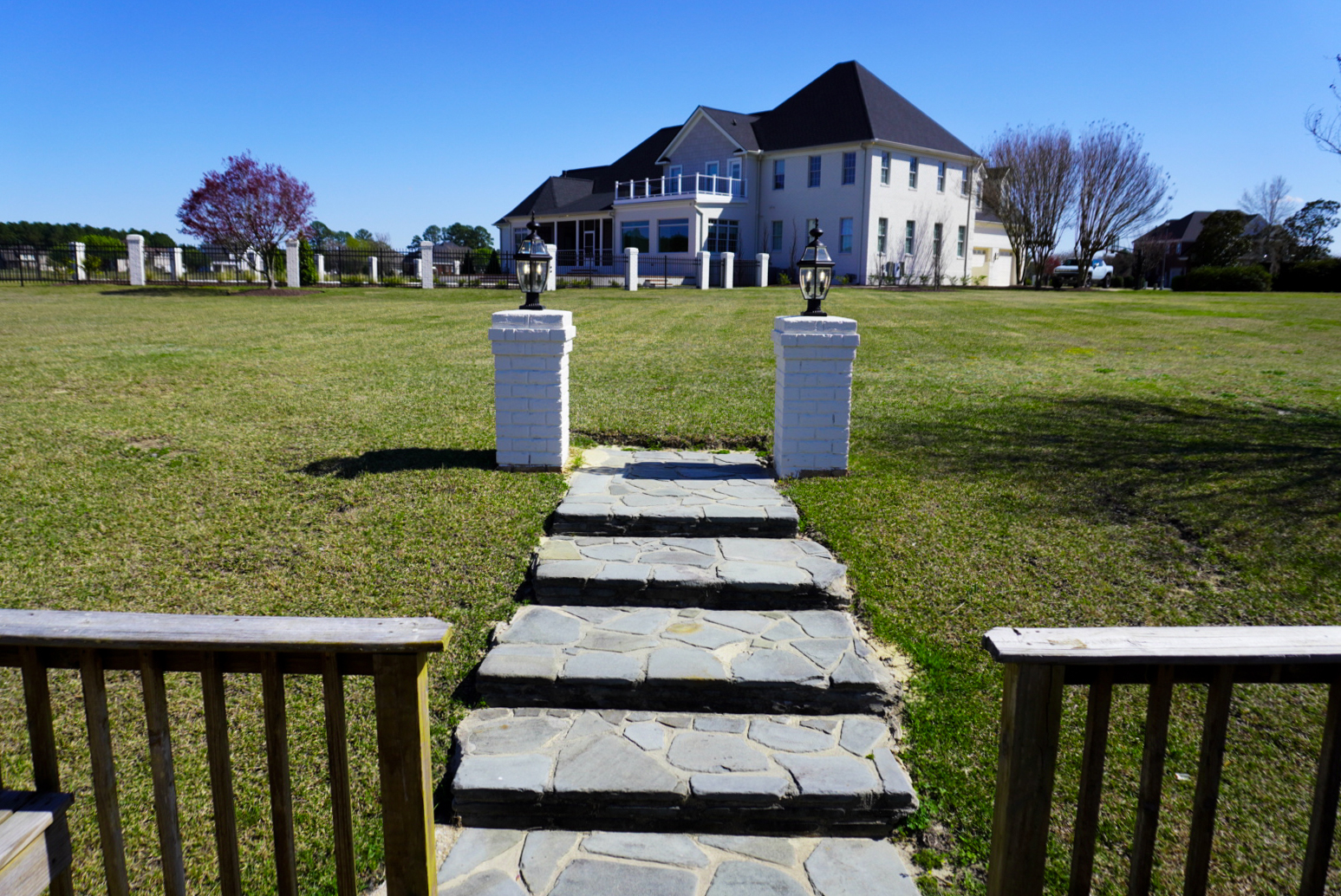 Flagstone walkway between stone pillars in a yard.