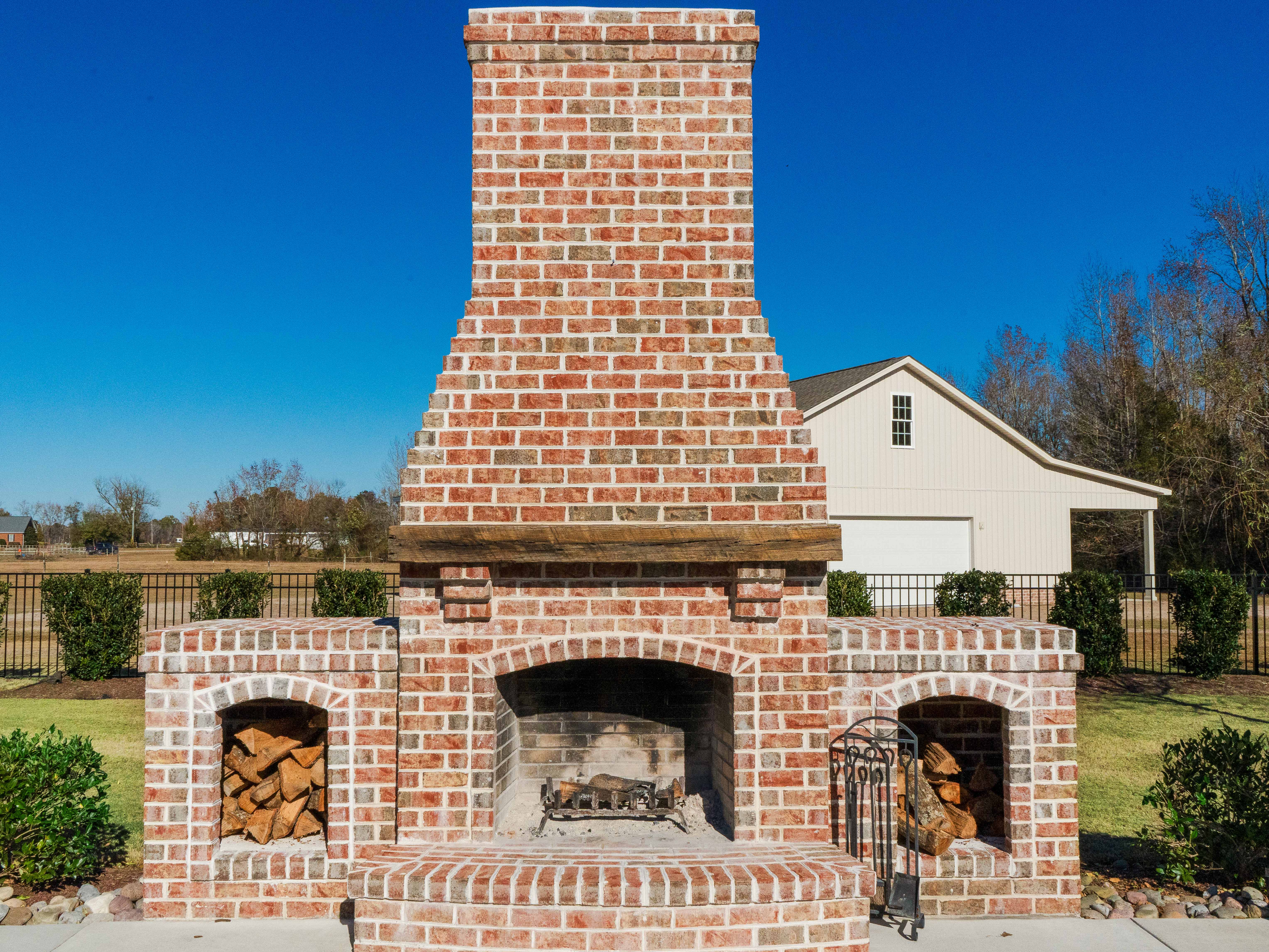 Freestanding brick fireplace with arched wood-storage alcoves.