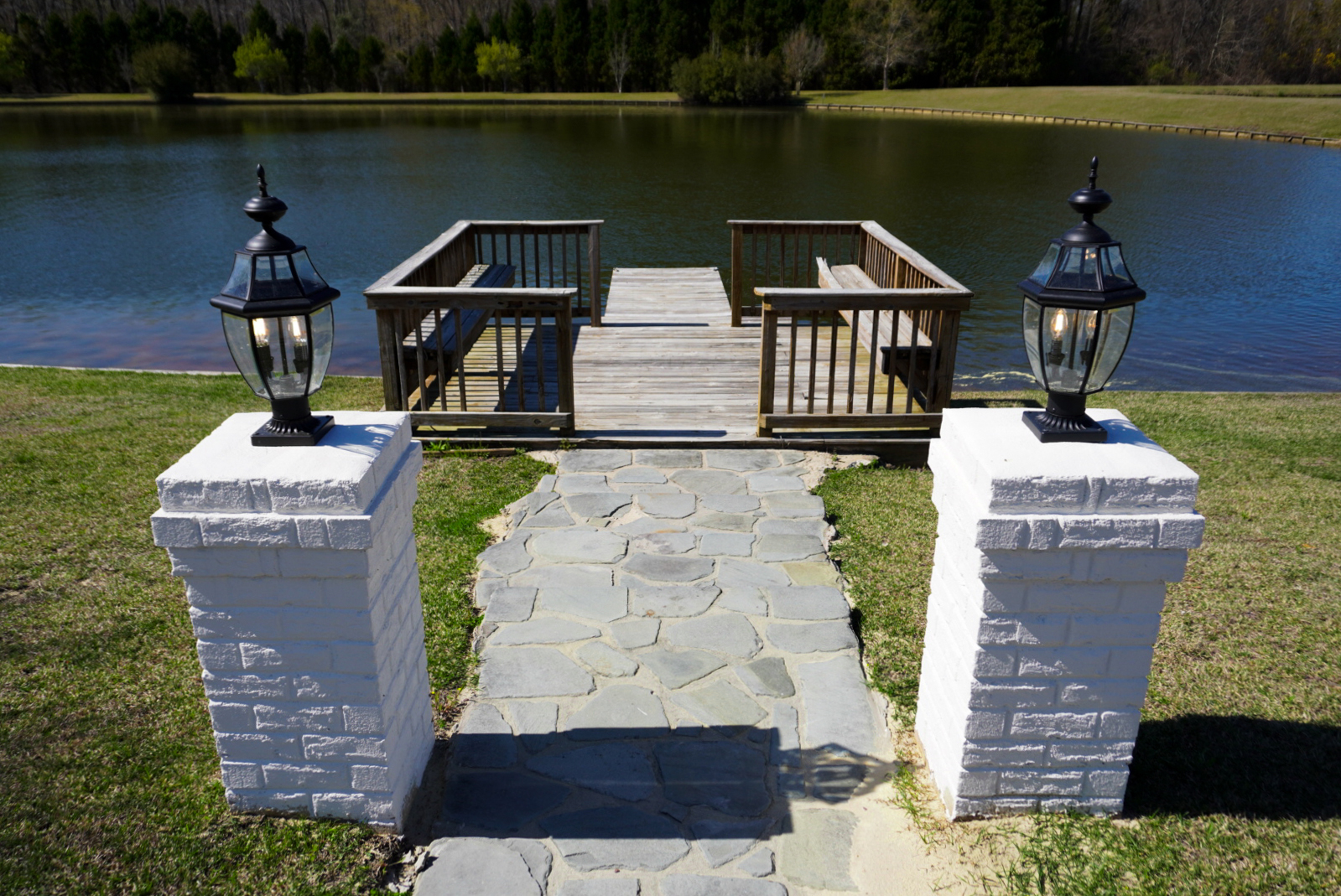 Pond dock with flagstone and pillars.
