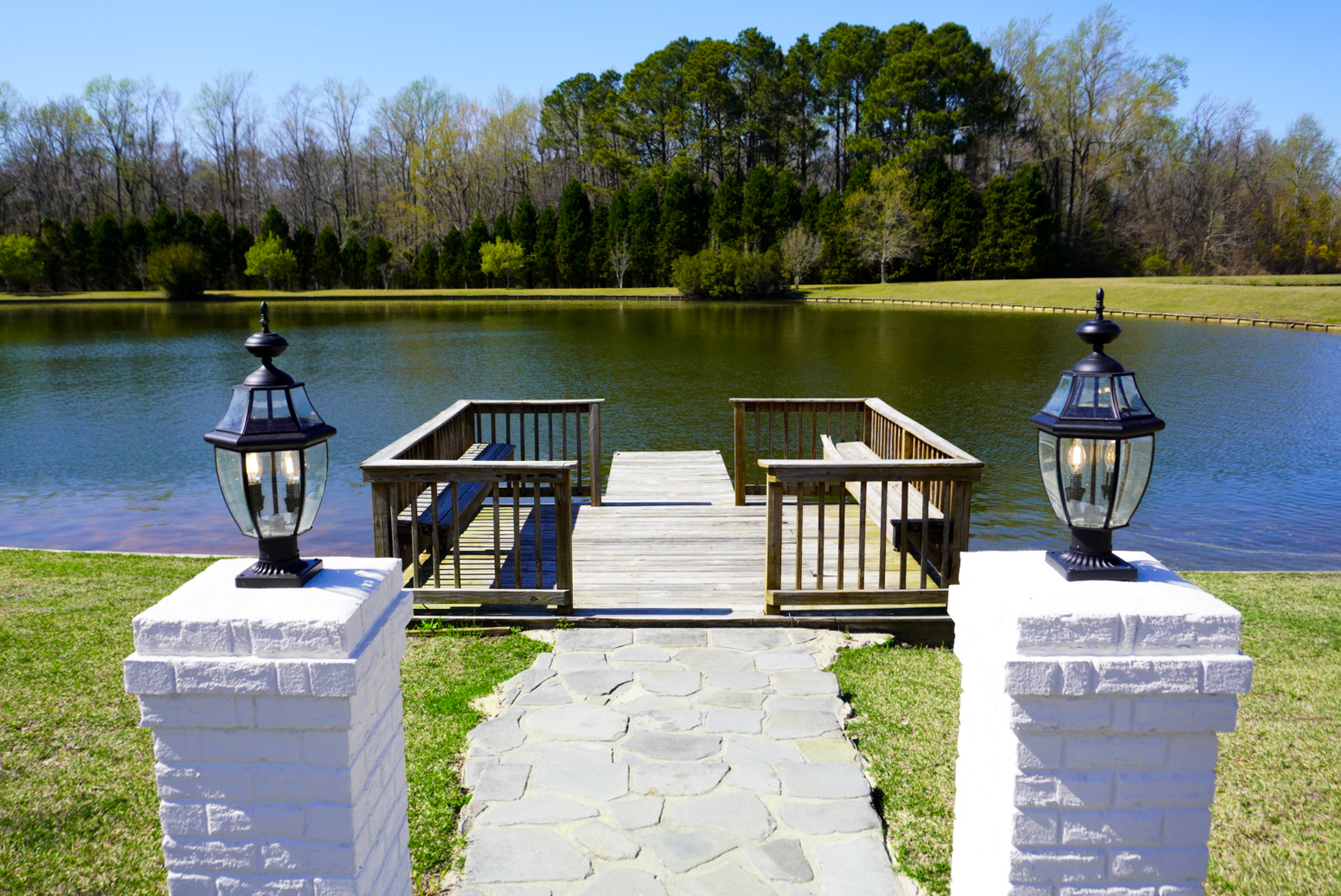 Pond dock with twin lantern pillars.