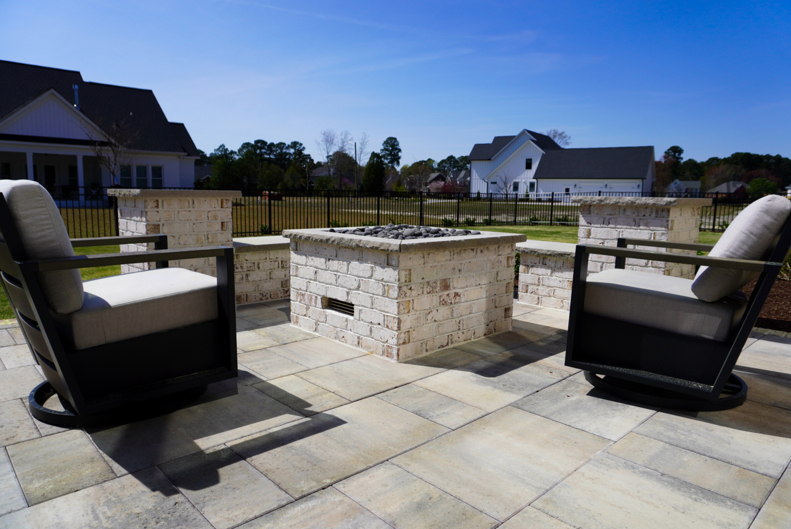 Rear-patio firepit with stone-veneer surround.