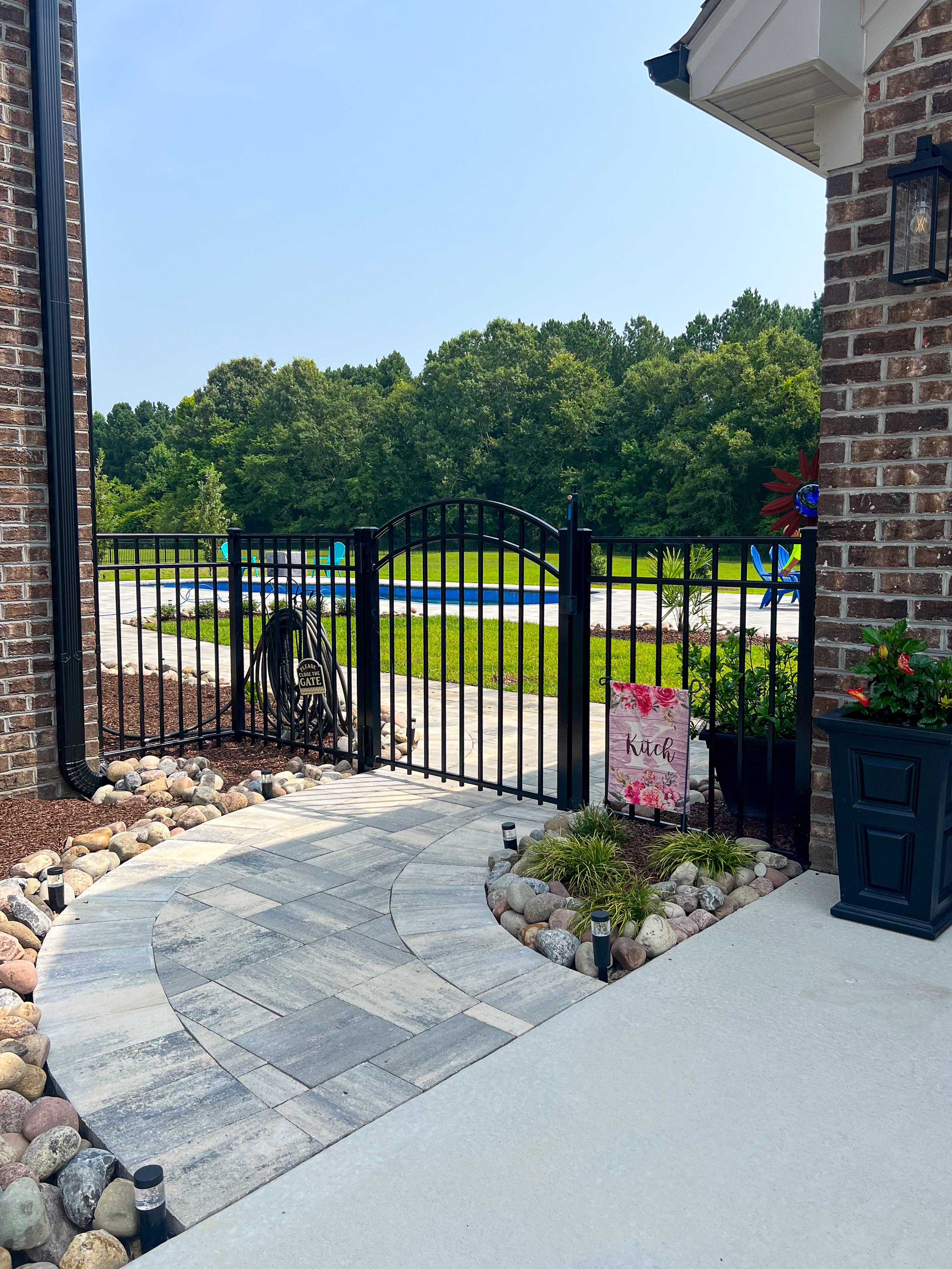 Brick courtyard pool — view through the gate.