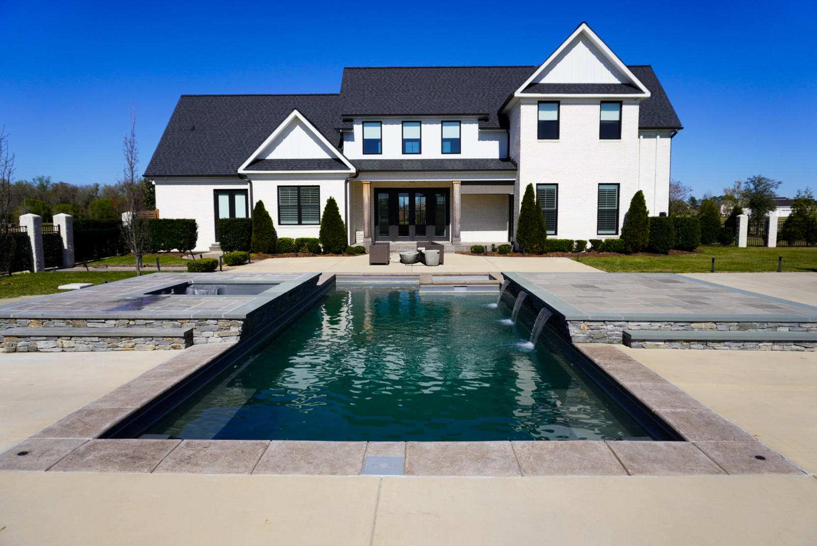 Modern farmhouse rear elevation with pool and spa.