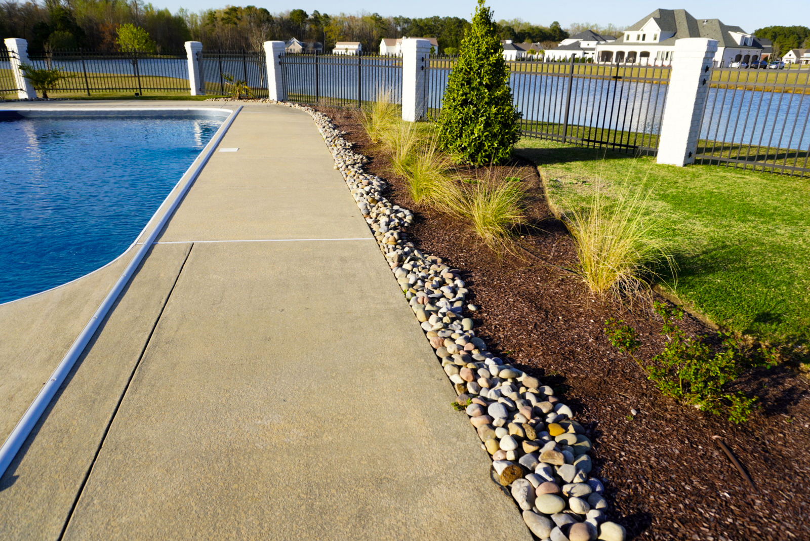 Poolside with river-rock border and pond.