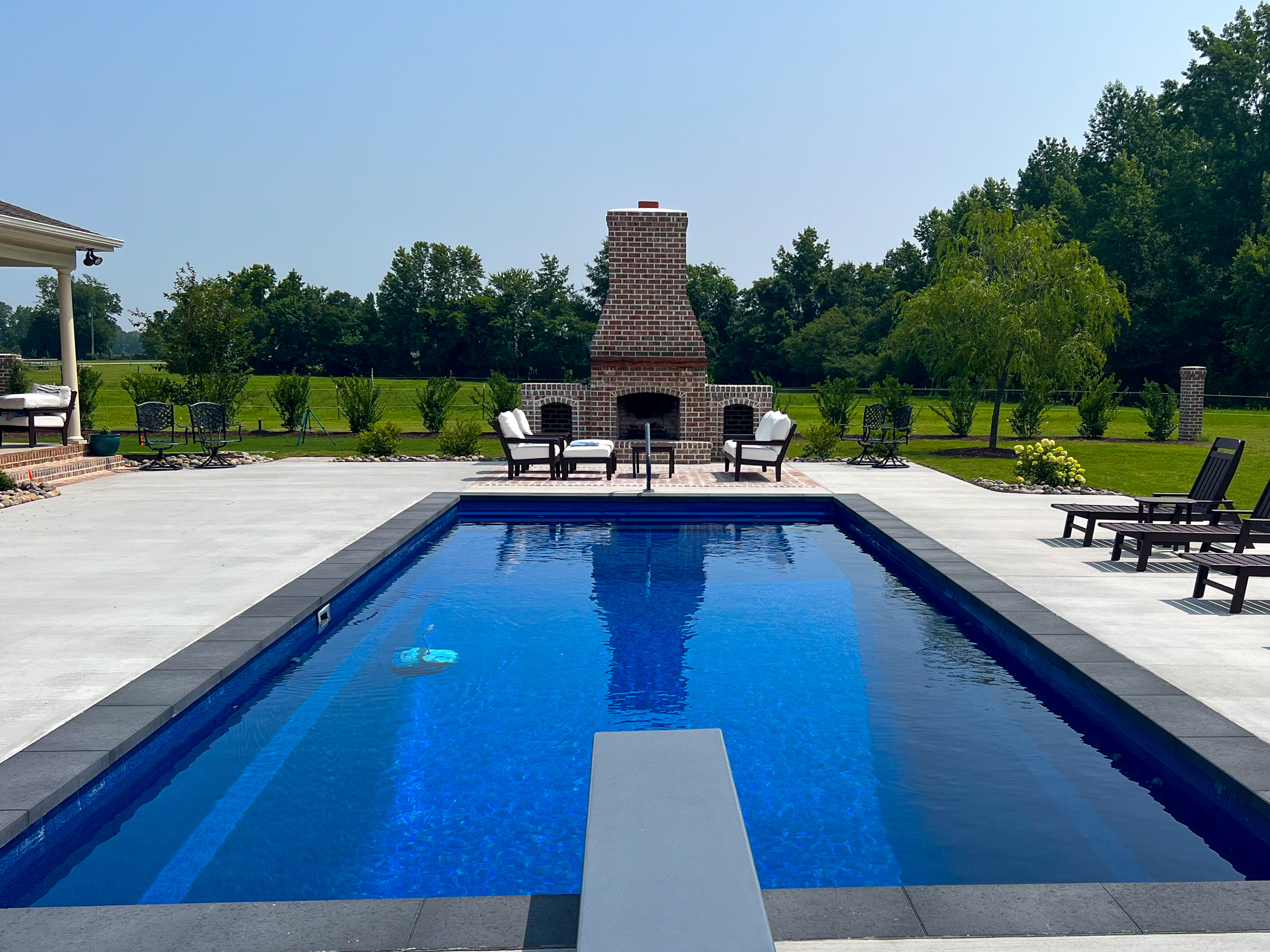 Rectangular pool with brick fireplace.