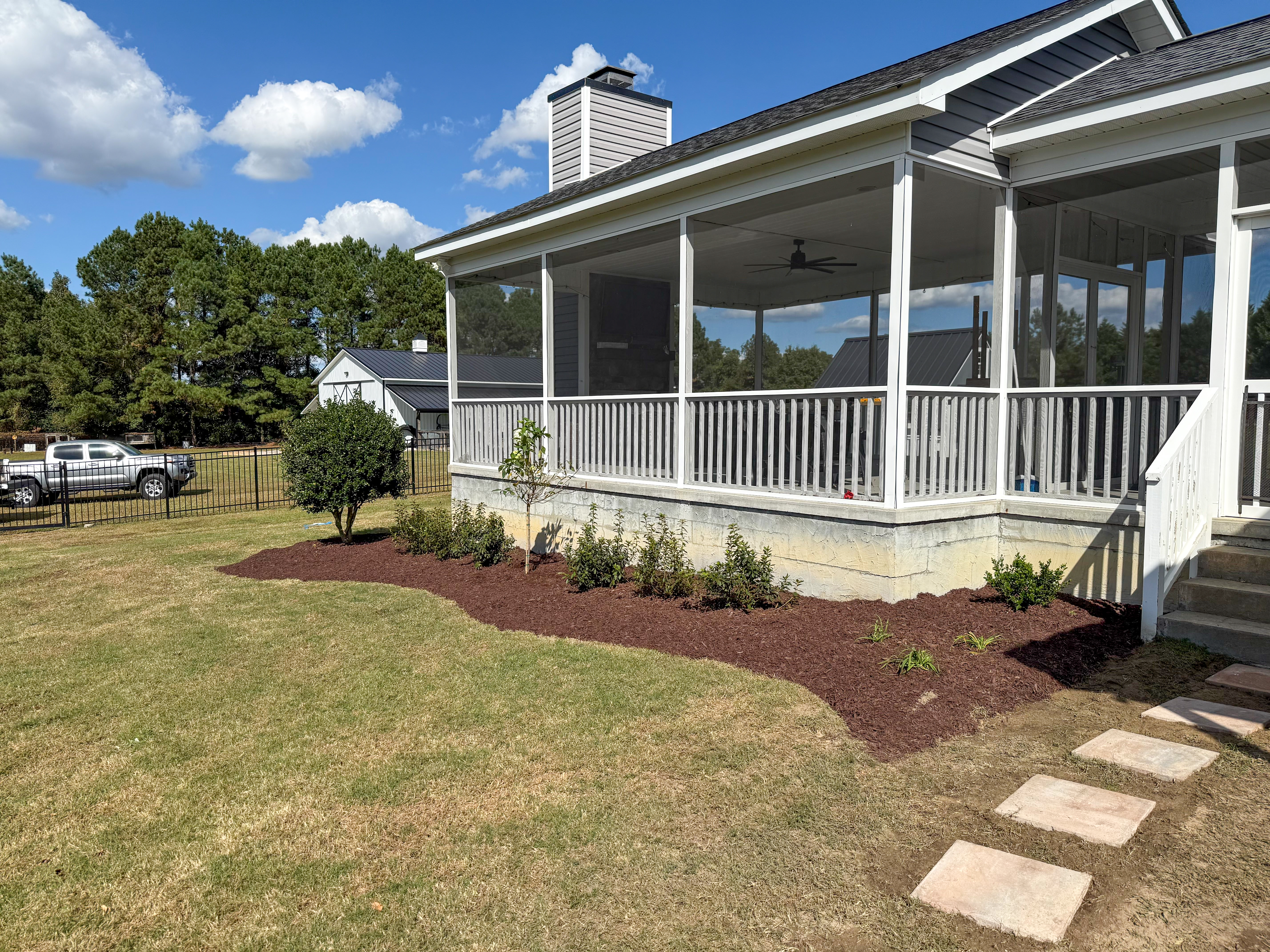 Screened porch with side foundation bed.